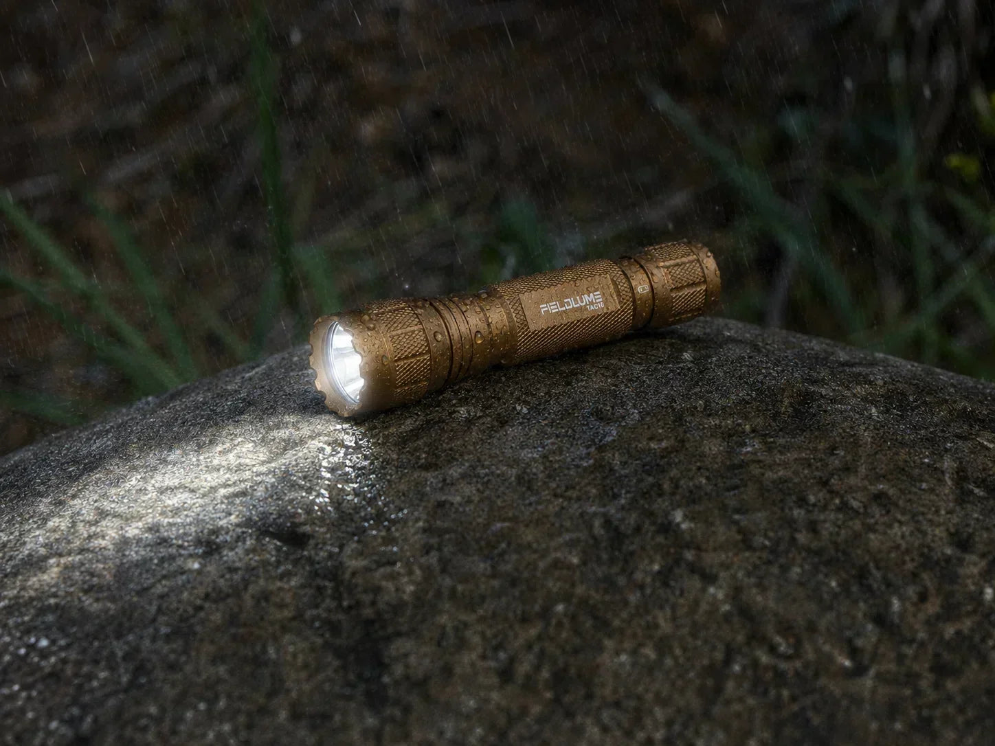 FIELDLUME TAC10 Tan tactical flashlight carried in an outdoor backpack pocket