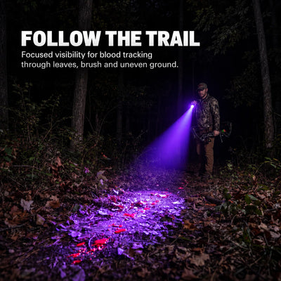 FIELDLUME B1 blood tracking light used by a hunter to follow a blood trail through leaves and brush at night