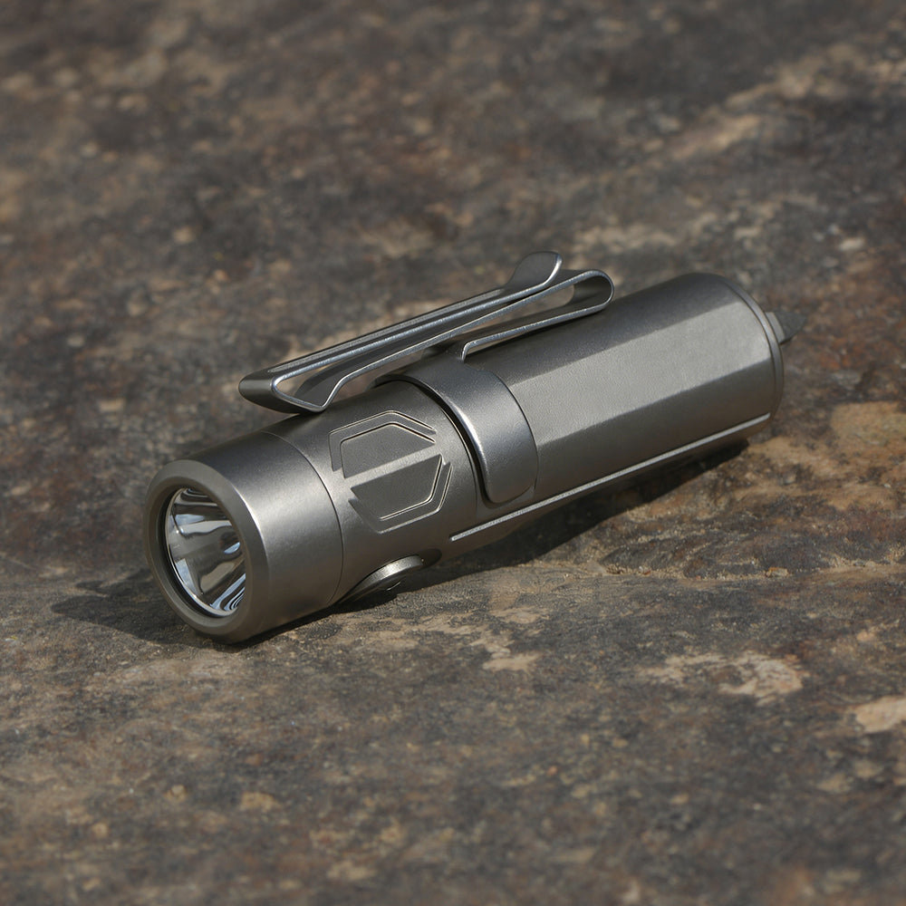 Silver flashlight on a textured brown surface pocket size torch