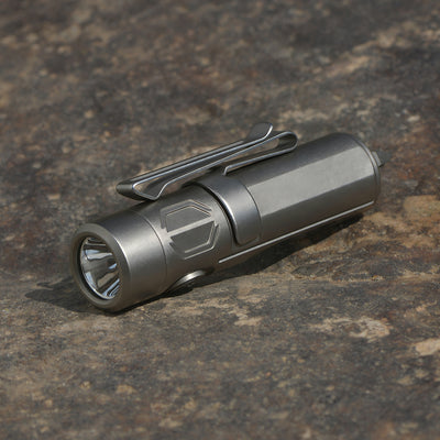 Silver flashlight on a textured brown surface pocket size torch