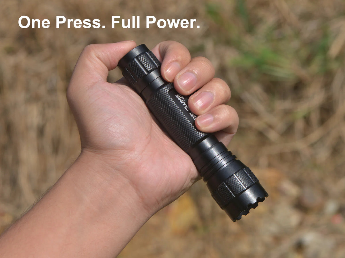 Hand holding FIELDLUME TAC10 with thumb pressing the power switch