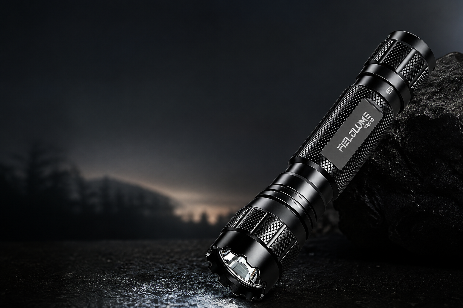 FIELDLUME TAC10 compact torch on a rugged outdoor surface at night